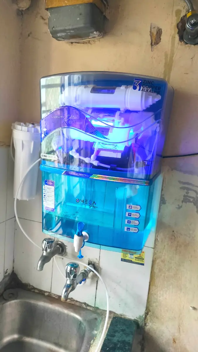 Blue wall-mounted RO purifier installed above a kitchen sink